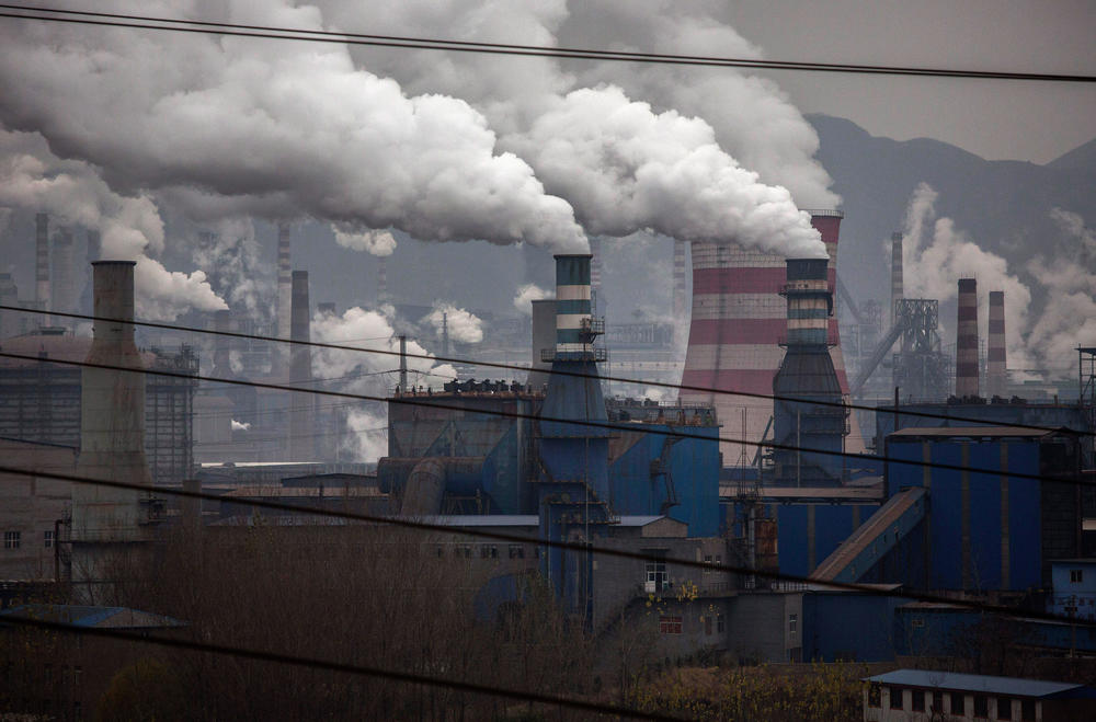 Smoke billows from smokestacks and a coal-fired power plant at a steel factory in China.