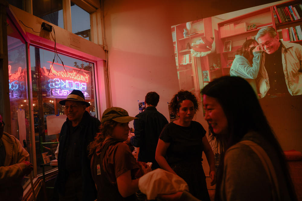 A photo of Harvey  and employee Cheryl Truong, taken by Berkeleyside photographer Ximena Natera, is projected onto the wall at the farewell event.