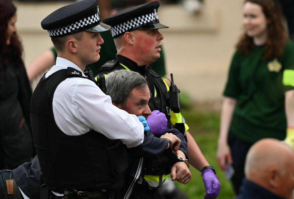Police officers take away protesters near to the 'King's Procession'.