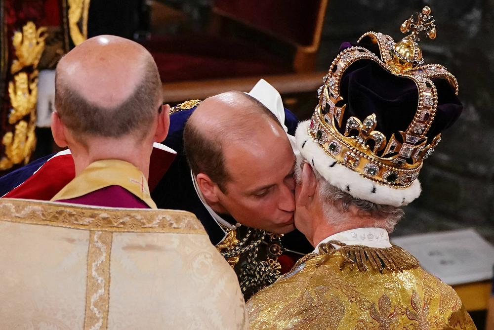 Britain's Prince William, Prince of Wales kisses his father, Britain's King Charles III, wearing St. Edward's Crown, during the King's Coronation Ceremony inside Westminster Abbey.