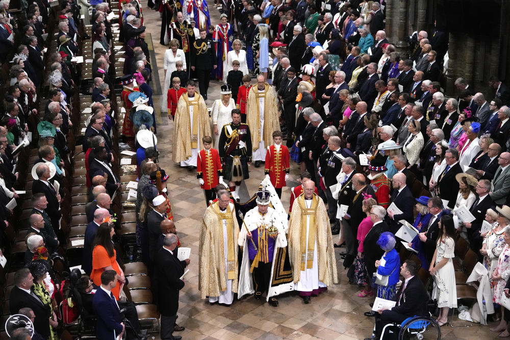 King Charles III, front center, and Queen Camilla, middle center, walk in the Coronation Procession at Westminster Abbey.