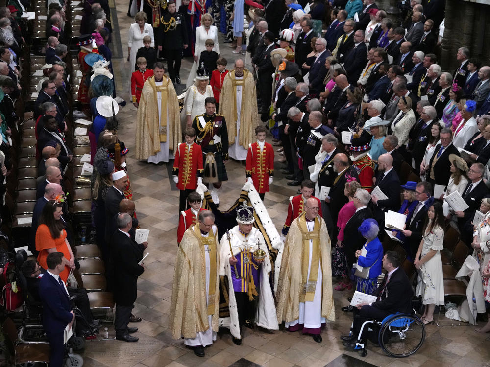 King Charles III, front center, and Queen Camilla, middle center, walk in the Coronation Procession after his coronation ceremony at Westminster Abbey on Saturday.