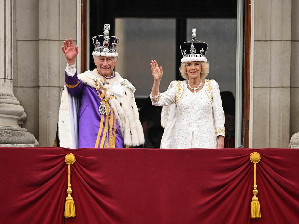 Britain's King Charles III wearing the Imperial state Crown, and Britain's Queen Camilla wearing a modified version of Queen Mary's Crown wave from the Buckingham Palace balcony after viewing the Royal Air Force fly-past in central London on Saturday.
