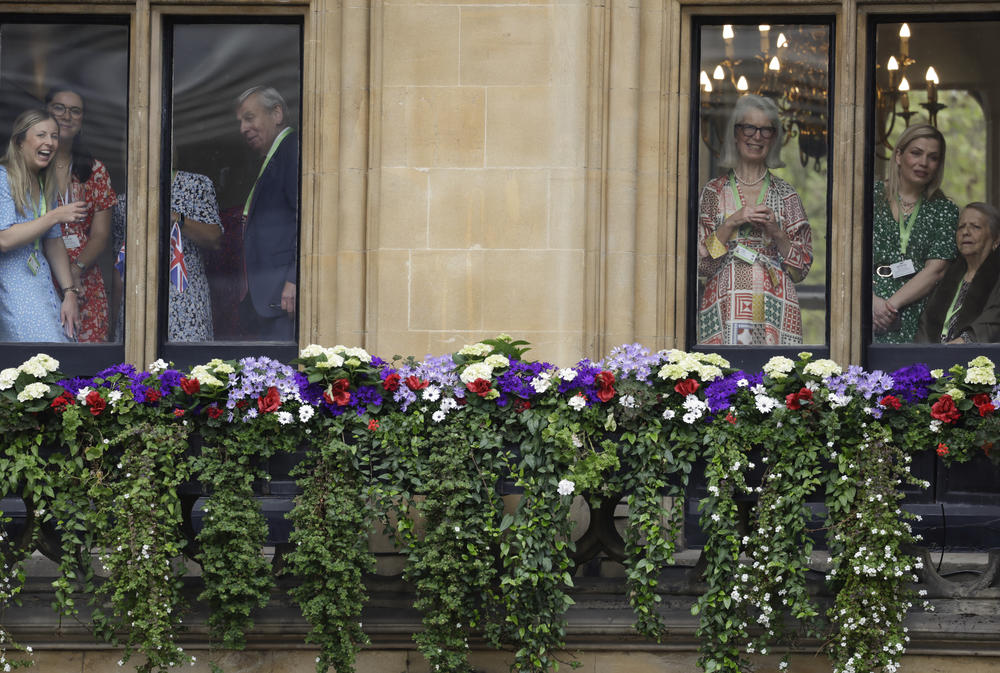 Members of the public look out onto Parliament Square ahead of the Coronation of King Charles III and Queen Camilla.