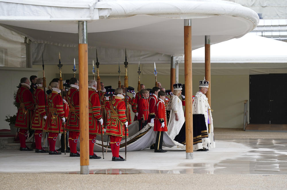 Britain's King Charles III, right, and Queen Camilla arrive to receive a royal salute from members of the military in the gardens of Buckingham Place, following his coronation.