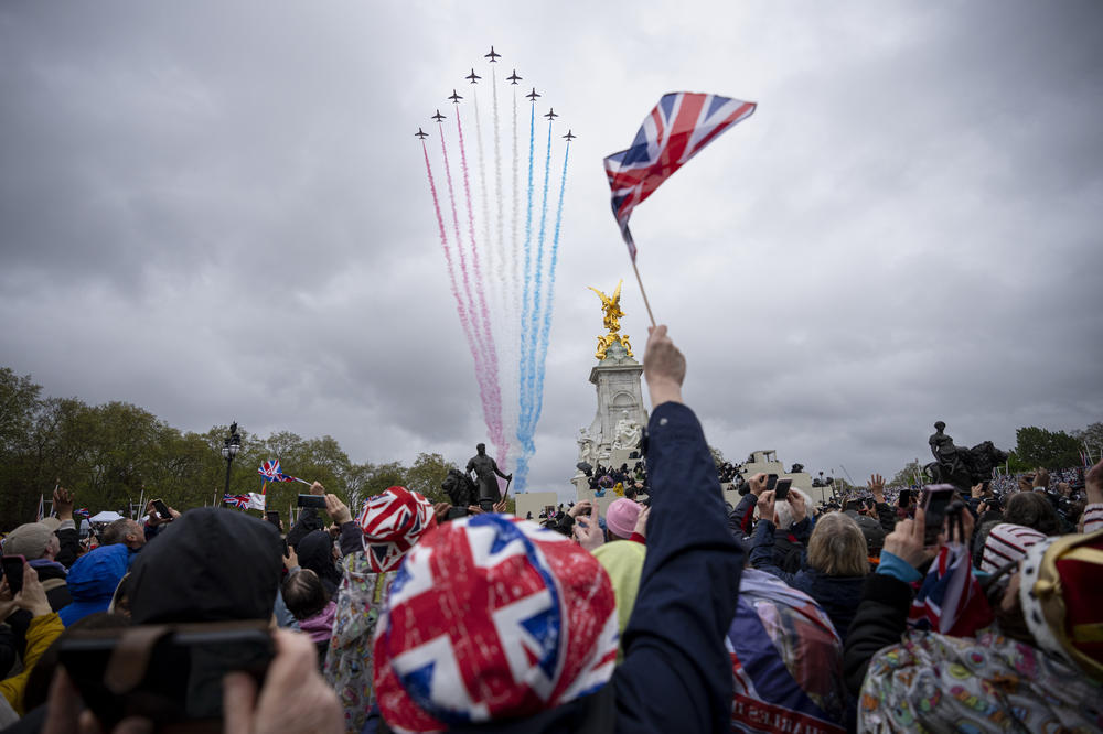 People watch the fly past near Buckingham Palace after the coronation ceremony.