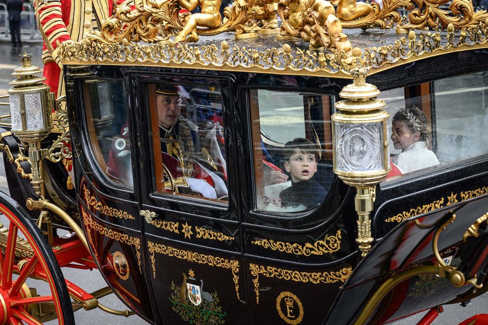 Britain's Prince Louis of Wales reacts as he travels back with his family to Buckingham Palace from Westminster Abbey in central London.