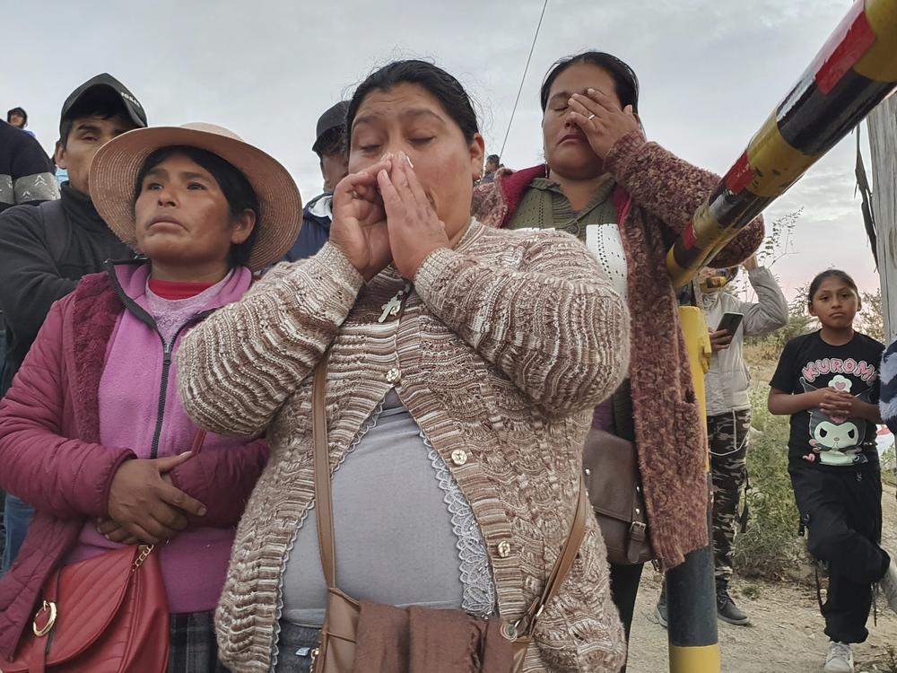 Relatives of trapped miners wait outside the SERMIGOLD mine in Arequipa, Peru, Sunday, May 7, 2023. The Public Ministry confirmed the death of 27 miners, who were trapped early Saturday morning due to an explosion in a tunnel inside the artisanal mine located in Yanaquihua district in Arequipa.