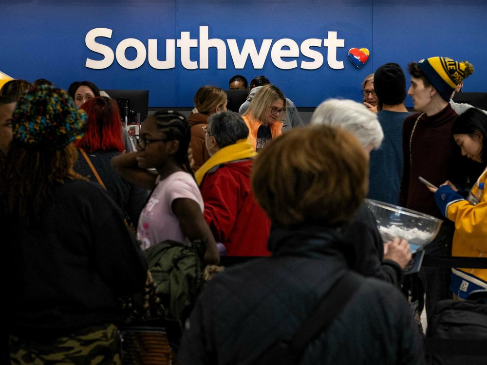 Travelers wait in line at the Southwest Airlines ticketing counter at Nashville International Airport after the airline cancelled thousands of flights in Nashville, Tennessee, on December 27, 2022.