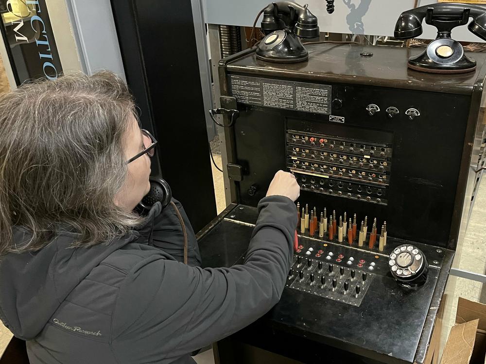 A visitor at the Connections Museum works the kind of switchboard system that first connected American phone users.