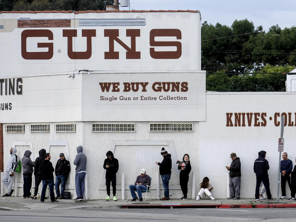 In this March 15, 2020 file photo people wait in a line to enter a gun store in Culver City, Calif.