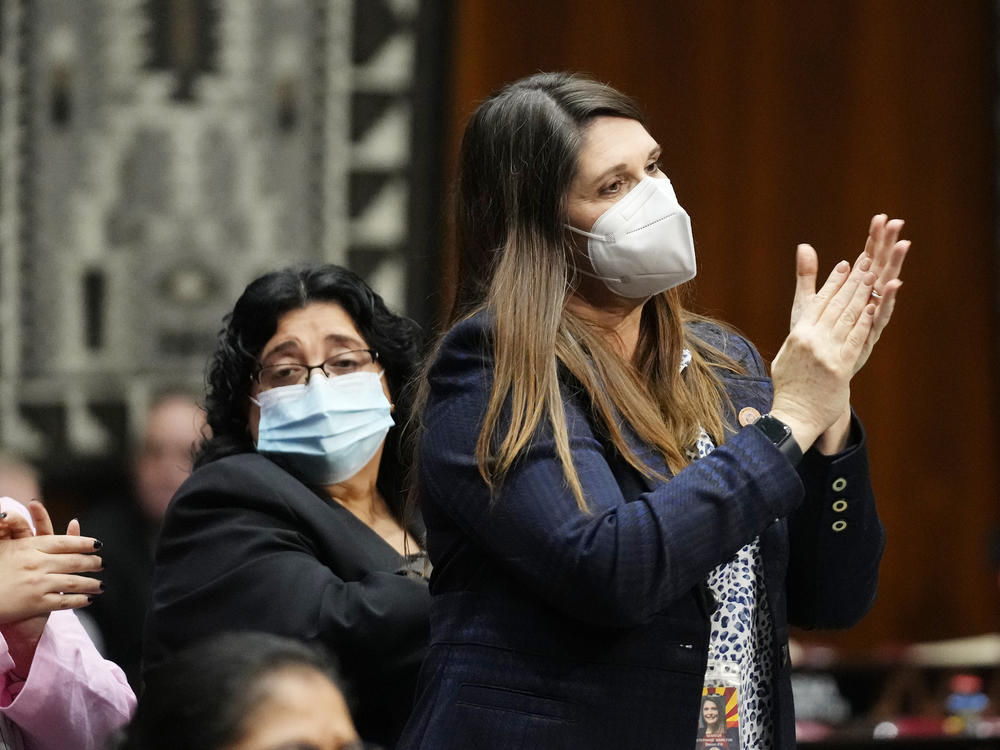 Democratic state Sen. Stephanie Stahl Hamilton (right) stands and applauds as Arizona Democratic Gov. Katie Hobbs gives the state address at the Arizona Capitol in Phoenix on Jan. 9.