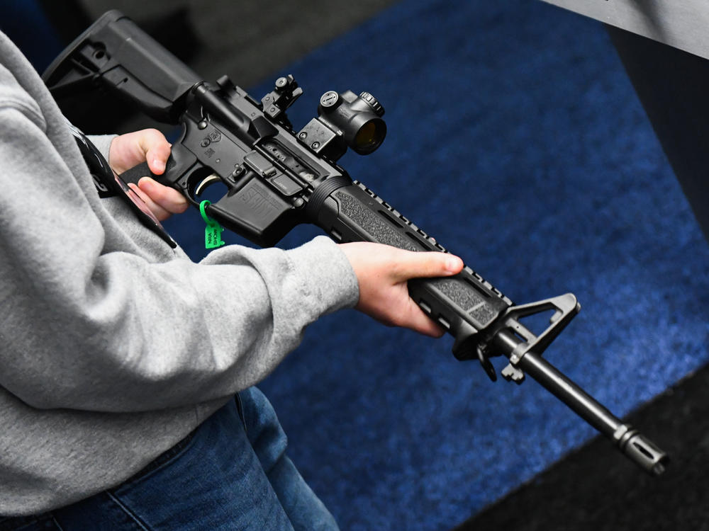 An attendee holds a Springfield Armory SAINT AR-15-style rifle displayed during the National Rifle Association Annual Meeting in Houston in 2022.