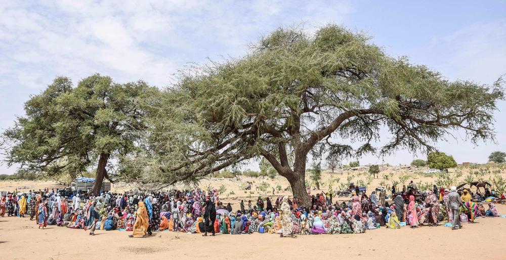 Sudanese refugees who crossed into neighboring Chad receive aid at a distribution center on April 30. A growing number of Sudanese are fleeing their country following recent fighting between two rival generals in Sudan's capital Khartoum.