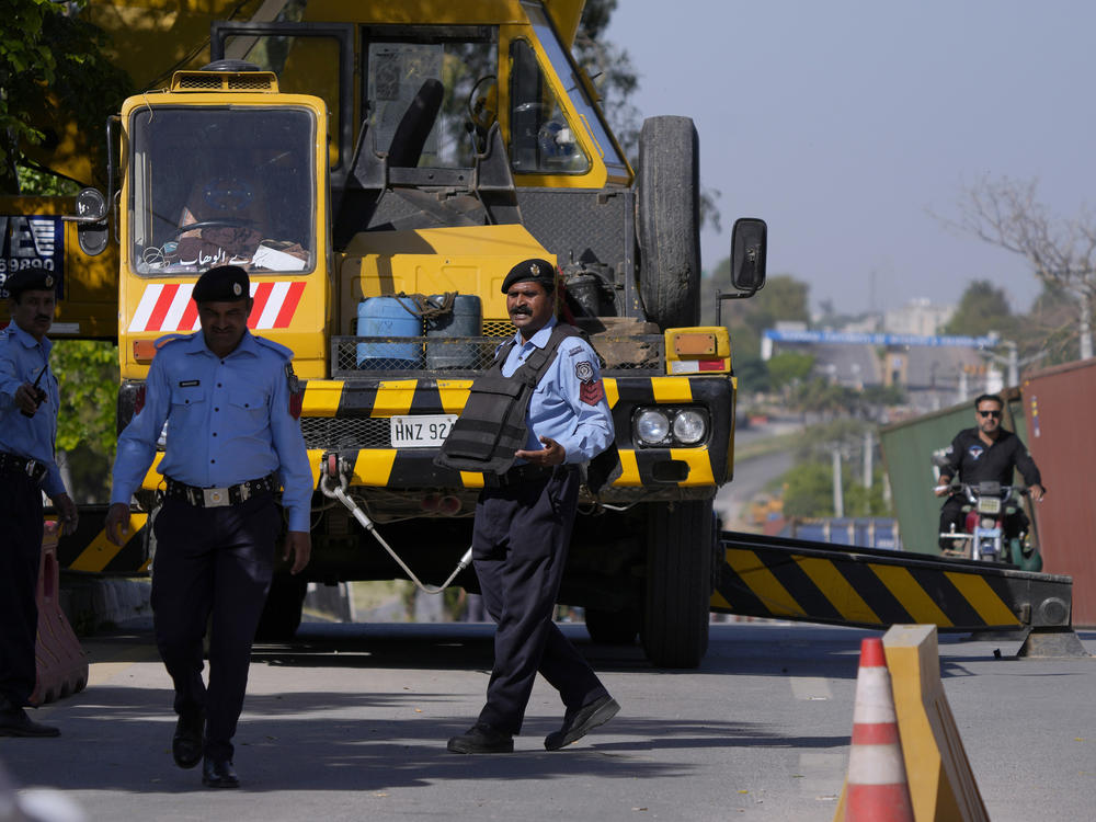 Police officers stand guard at the vicinity of police headquarters, where Pakistan's former Prime Minister Imran Khan appeared in a temporary court set up by authorities for security reasons, in Islamabad, Pakistan, Wednesday. Khan's party called for demonstrators to remain peaceful after mobs angered over Khan's arrest set fire to the residence of a top army general in the eastern city of Lahore.