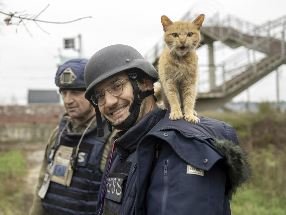 Agence France-Presse journalist Arman Soldin smiles as a cat stands on his shoulders in November in Ukraine. Colleagues of Soldin, who was killed in Ukraine on Tuesday, gathered solemnly at the press agency's Paris headquarters the day after his death to remember the 32-year-old.