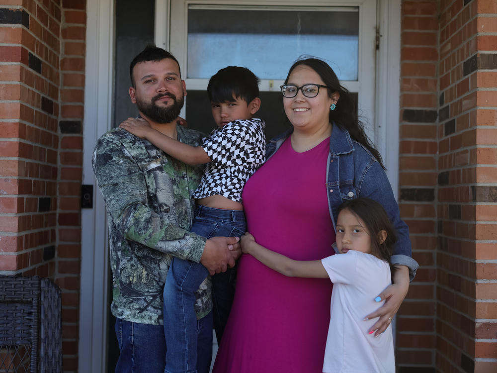 Cloie Davila, her daughter, Amelia, her husband, Joshua, and her son, Noah, stand outside their home in Clayton, New Mexico. Davila, who is expecting a third child, may be one of the last to benefit from a rural telehealth program for expectant mothers in New Mexico.