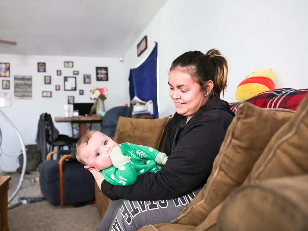 Jade Vandiver holds her son Ezra at home in Clayton, New Mexico. Vandiver joined a federally funded rural maternity program while pregnant with Ezra.