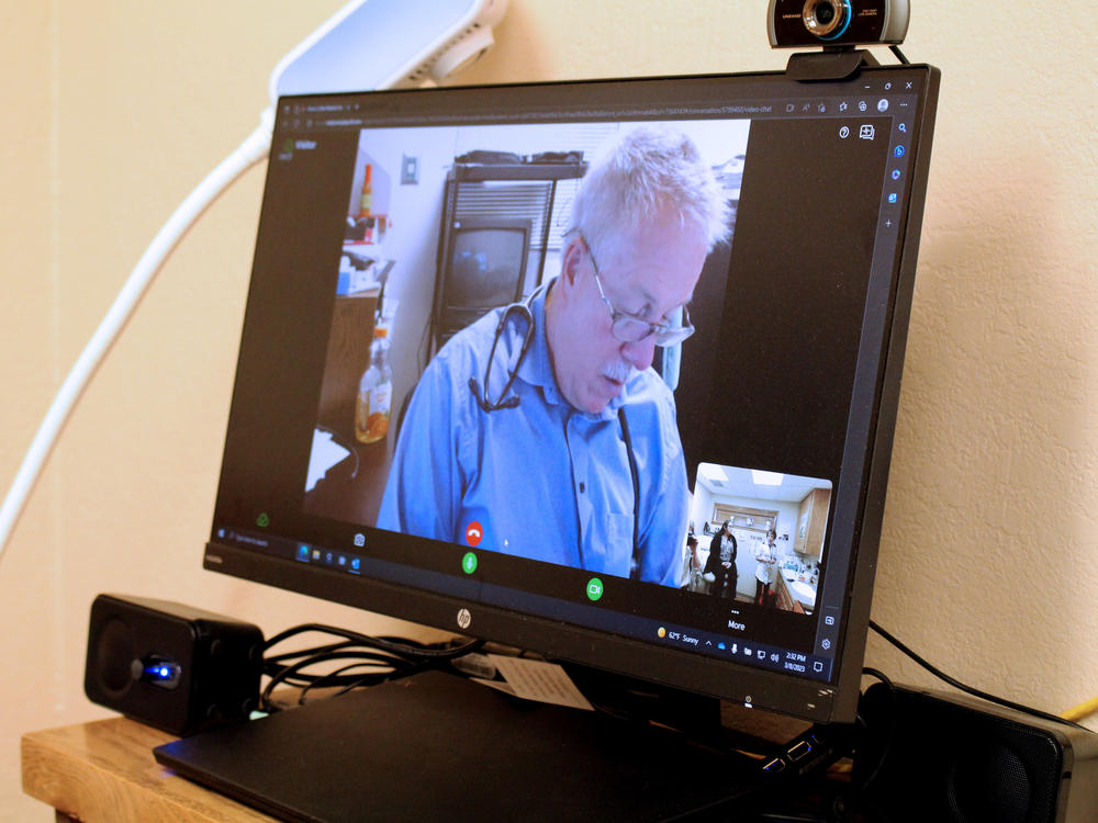 Timothy Brininger, a family practice doctor who specializes in obstetrics, is based in Raton, New Mexico. He reviews chart information while speaking via video call with prenatal patient Cloie Davila in Clayton, New Mexico.