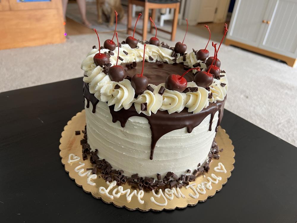 For her going away party, Josie's parents bought a black forest cake. Icing along the bottom spells out 