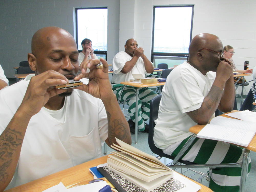 Inmate/students practice blues harmonica during a classroom session of the Blues Tradition in American Literature course inside Parchman Prison in Mississippi.