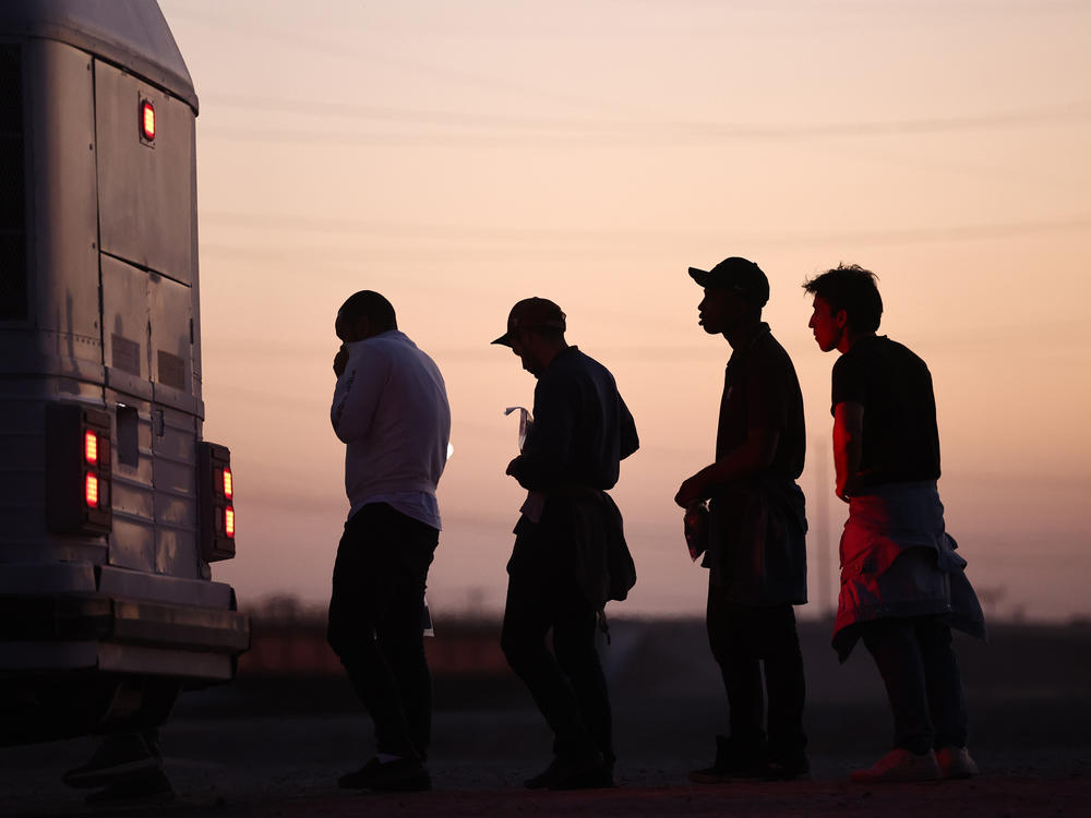 Immigrants seeking asylum wait to board a bus to a U.S. Border Patrol processing center, after crossing into Arizona from Mexico, on Thursday in Yuma, Ariz.