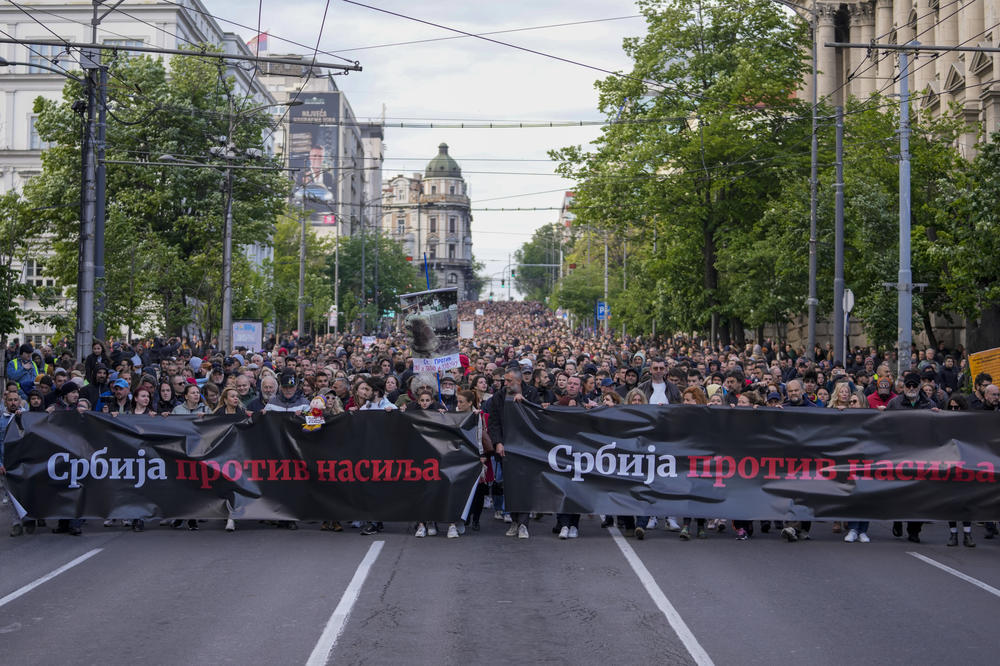 People hold banners with writing reading 
