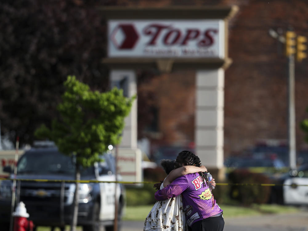 People hug outside the scene after a shooting at a supermarket on May 14, 2022, in Buffalo, N.Y.