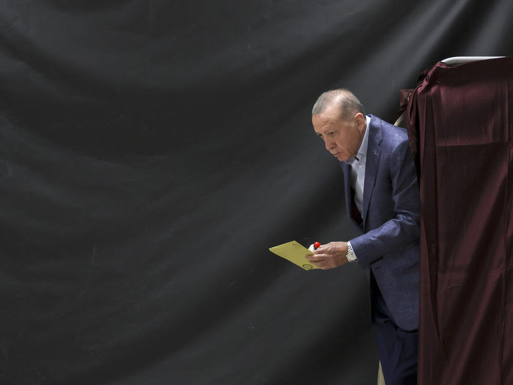 Turkish President Recep Tayyip Erdogan walks out of a voting booth at a polling station in Istanbul on Sunday.
