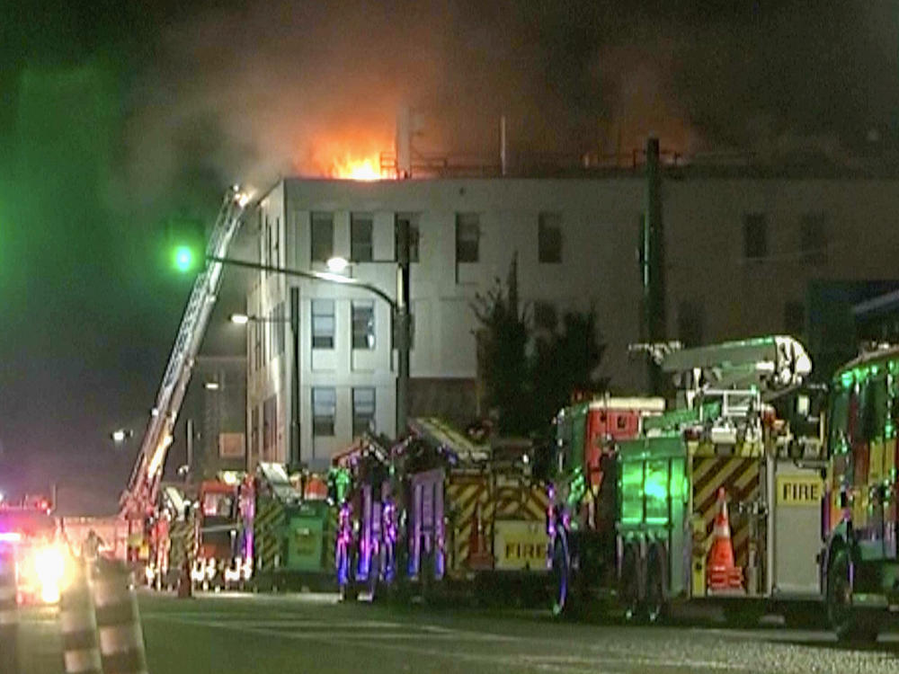 In this image made from video, firetrucks stage outside a hostel in central Wellington, New Zealand, early Tuesday, May 16, 2023. Several people were killed after a fire broke out overnight at the four-story building.
