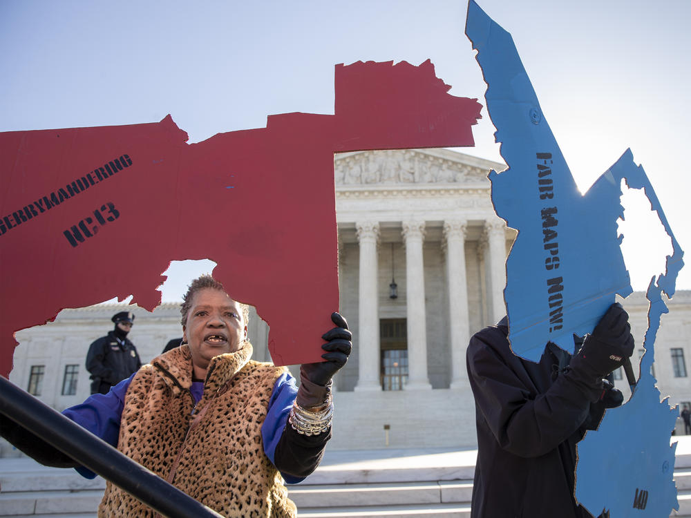 Demonstrators opposed to partisan gerrymandering hold up representations of congressional districts from North Carolina (left) and Maryland (right) outside the U.S. Supreme Court in Washington, D.C., in 2019.