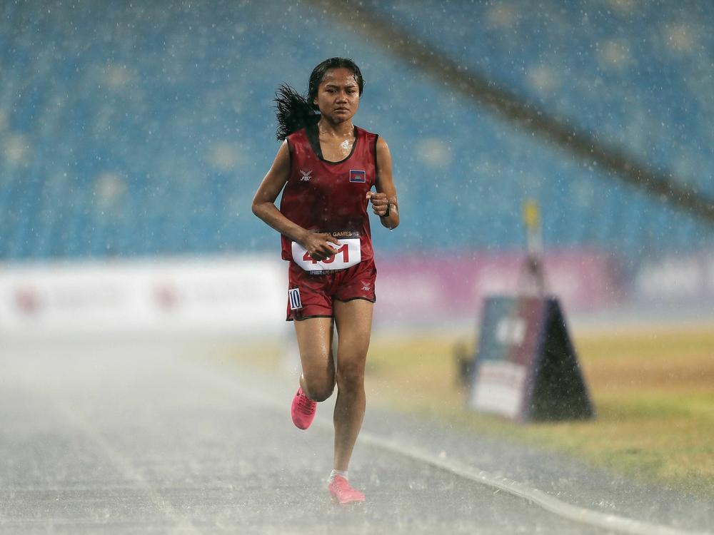 Cambodia's Bou Samnang runs in the women's 5,000-meter final despite heavy rain, during the Southeast Asian Games in Phnom Penh. A video of her finish, minutes after the race was decided, has won over fans around the sporting world.