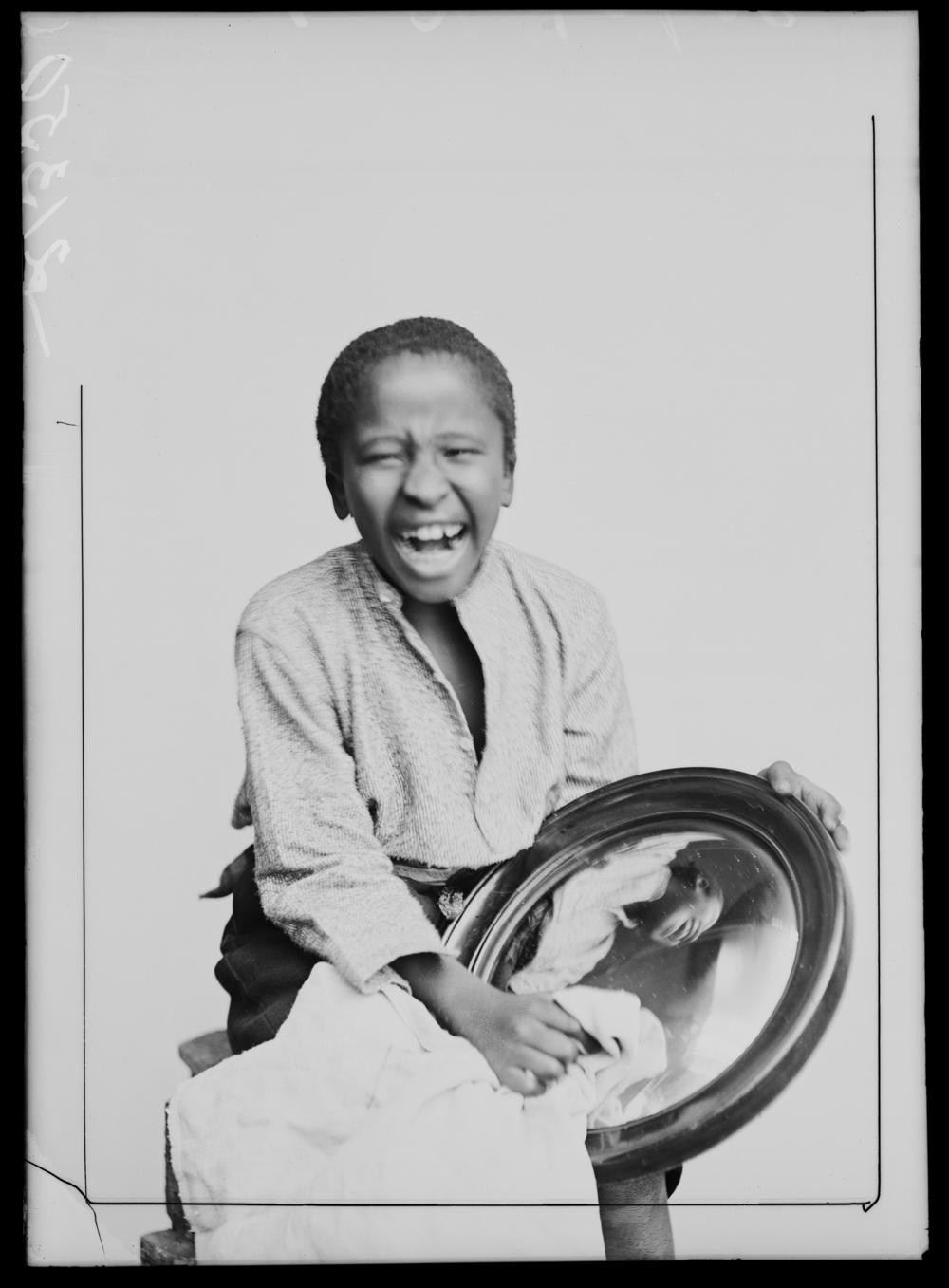 One of the members of The African Choir holds a mirror, 1891.