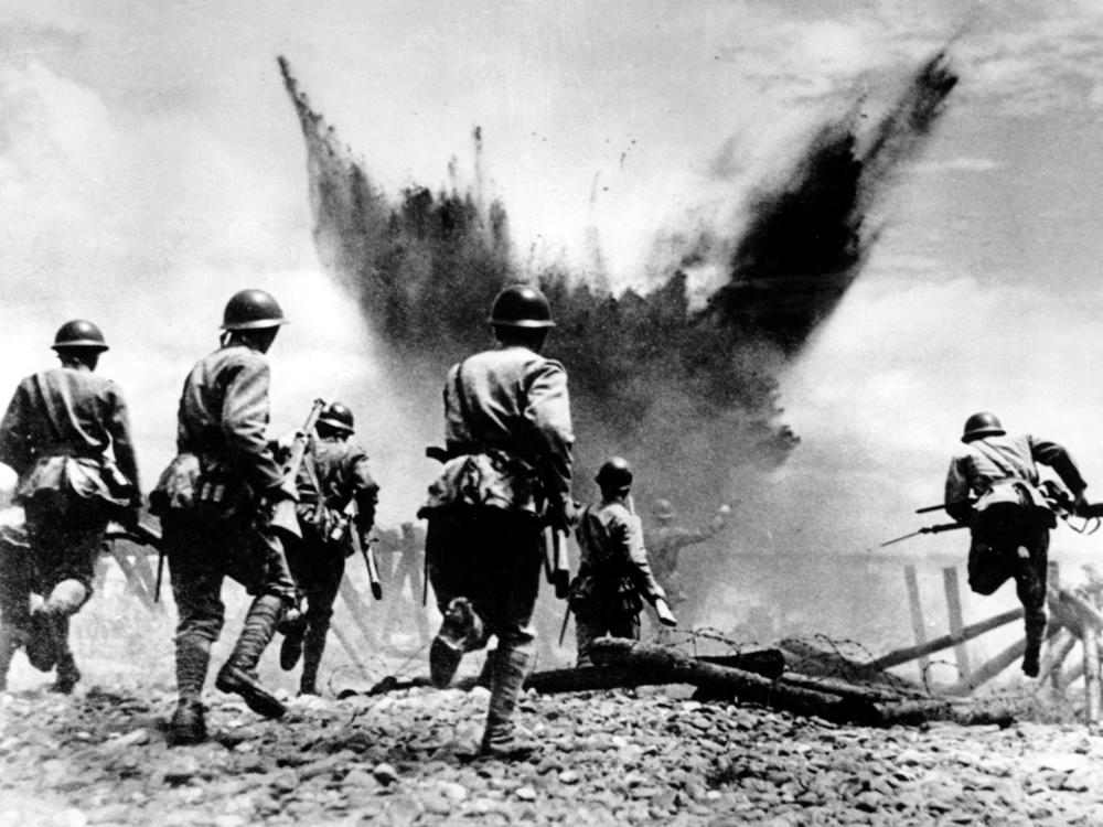 Japanese infantrymen advance with rifles and grenades, leaping over barbed wire and preceded by an artillery barrage, in the Peking sector in China on Aug. 19, 1937, during the Second Sino-Japanese War. Heavy casualties occurred on both sides, but Chinese losses outnumbered the Japanese five to one.