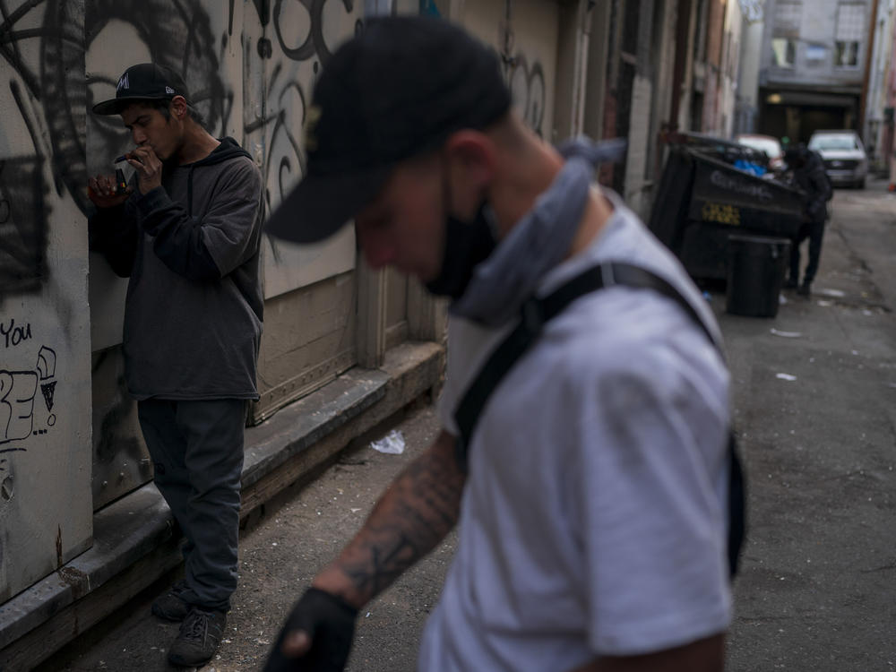 Two men smoke fentanyl in an alley in Los Angeles on April 18, 2022. The latest federal data show more than 109,000 drug deaths in 2022, many from fentanyl.