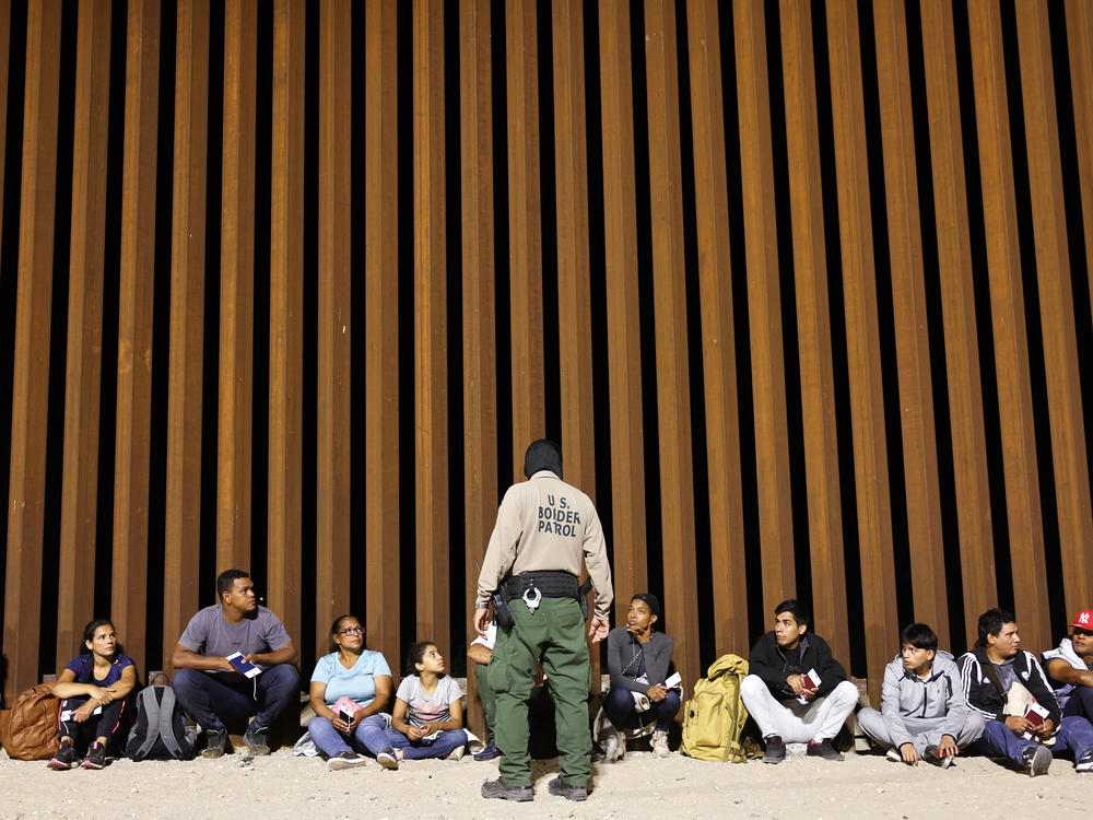 A border patrol agent speaks to people who were apprehended in Yuma, Arizona on May 11 a the U.S. border as Title 42 expired. The agency said on Wednesday that an 8-year-old girl died after being detained.