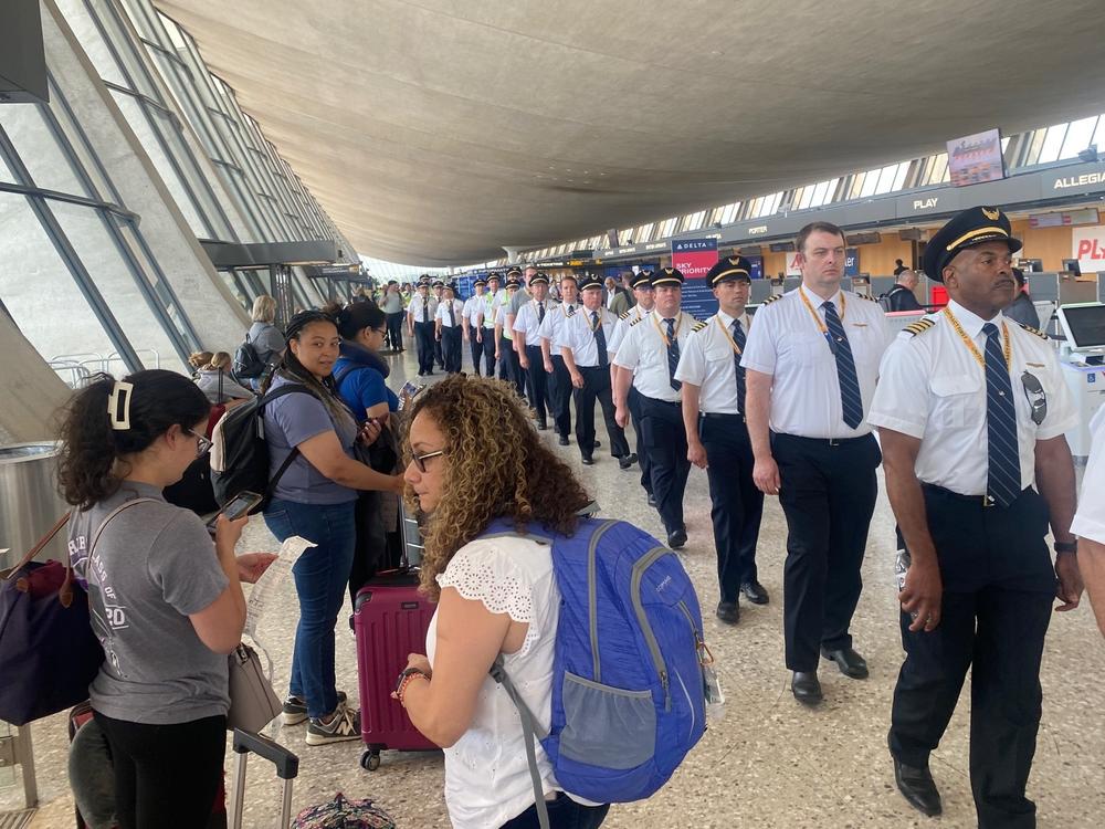 United pilots file through the departures hall at Washington Dulles Airport on May 12 as part of an informational picket.