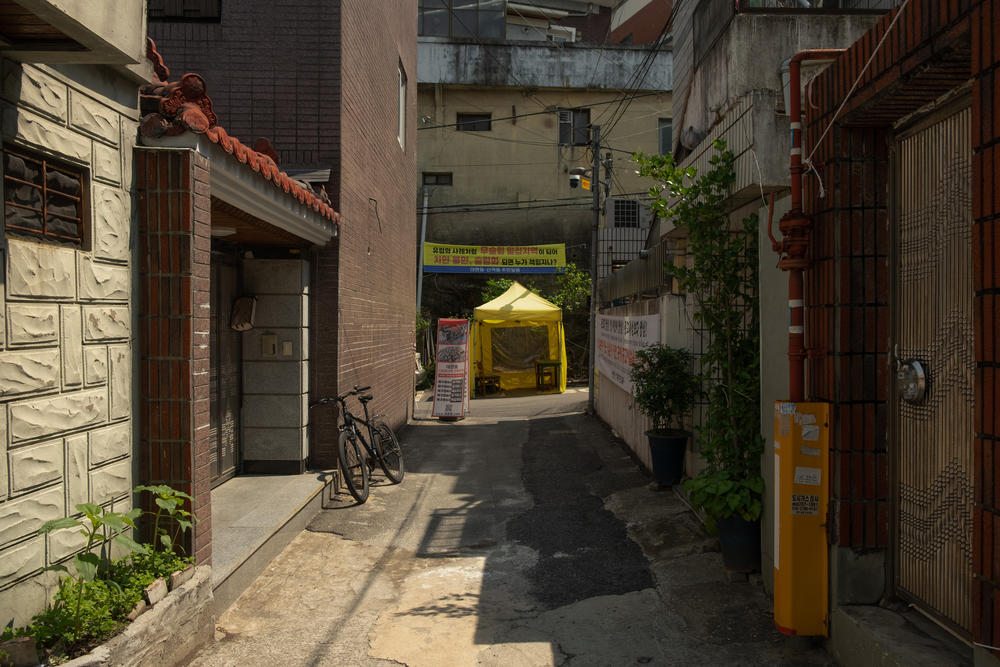 A view of the alleyway leading to the Islamic center. Residents opposed to a mosque's construction on the site sometimes sit at the entrance to the alleyway, watching the area from the yellow tent.