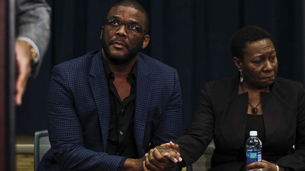 Media mogul Tyler Perry, left, holds the hand of Terrance Williams' mother, Marcia Williams. At the time, Perry offered a $100,000 reward for information solving the missing persons case of Terrance Williams and Felipe Santos. He later increased the offer to $200,000.