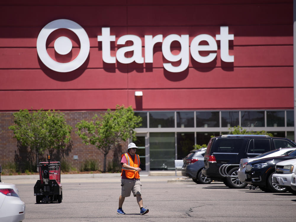A worker collects shopping carts in the parking lot of a Target store on June 9, 2021, in Highlands Ranch, Colo.