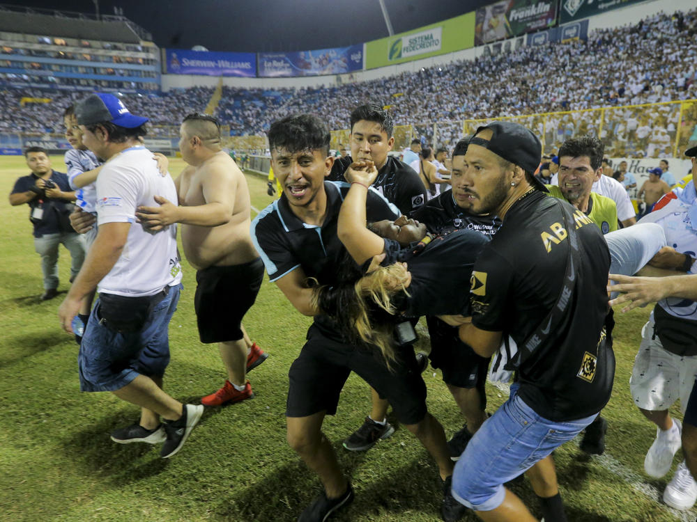 An injured fan in carried to the field of Cuscatlan stadium in San Salvador, El Salvador, Saturday, May 20, 2023. At least nine people were killed and dozens more injured when stampeding fans pushed through one of the access gates at a quarterfinal Salvadoran league soccer match between Alianza and FAS.