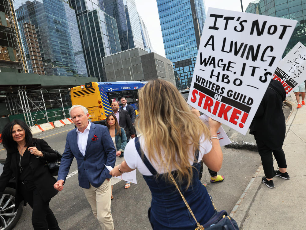 Writers Guild of America East members hand out flyers as they walk a picket line in New York on May 16.