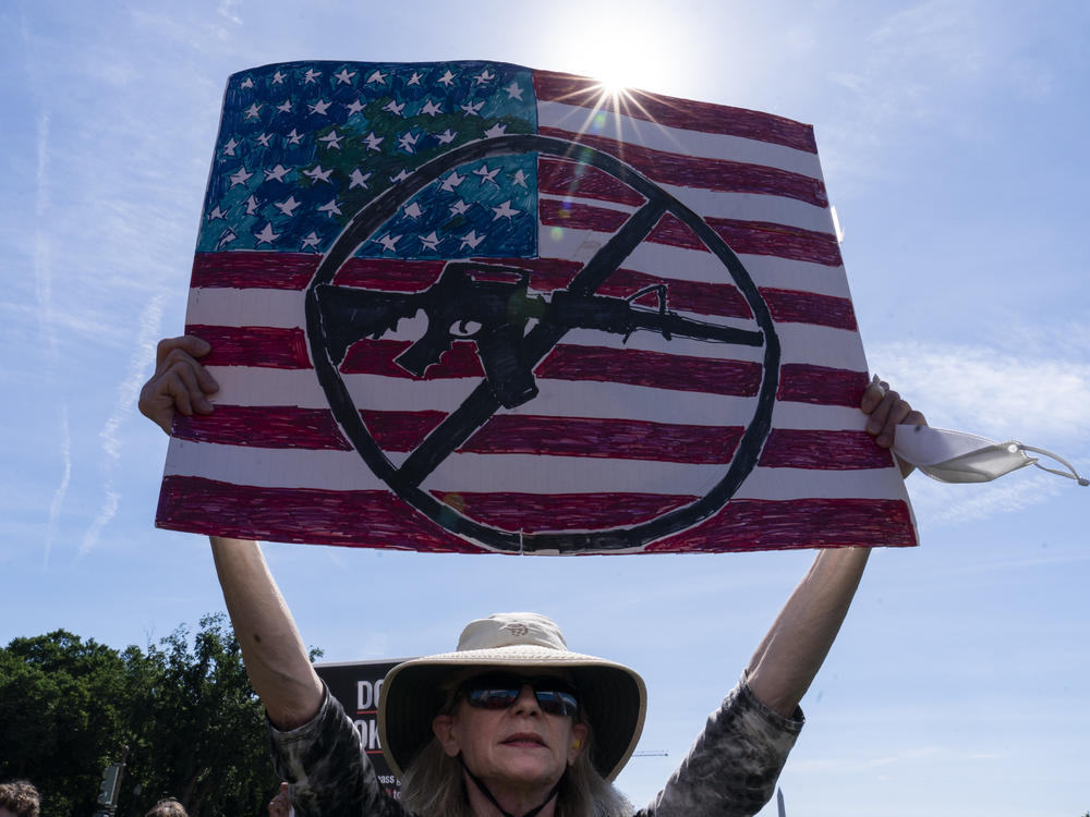 FILE - A protestor holds a sign during a Students Demand Action event, near the U.S. Capitol, Monday, June 6, 2022, in Washington.