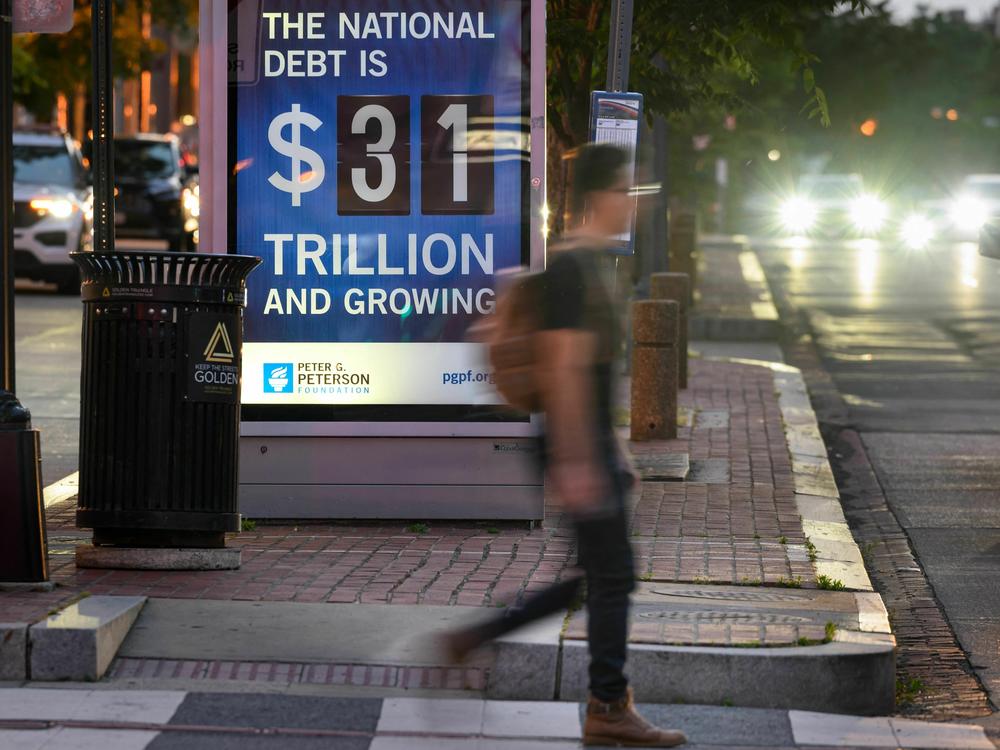 A poster at a bus shelter in Washington, D.C., on May 21 shows the national debt. The U.S. is facing the prospect of default as political leaders race to clinch a deal to raise or suspend the debt ceiling. Currently the country can borrow up to $31.4 trillion.