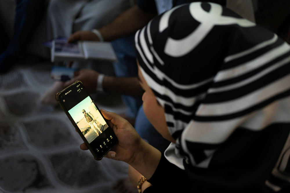 Aliaà, Shihab's younger sister, looks at photos of him on her phone. She says when Shihab died, 