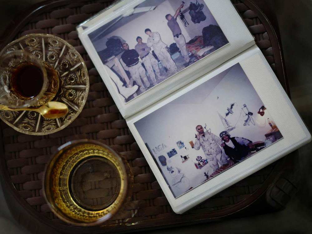 A photo album of Shihab — during his time as an interpreter working with American military personnel during the Iraq War — rests on a small table alongside cups of tea.