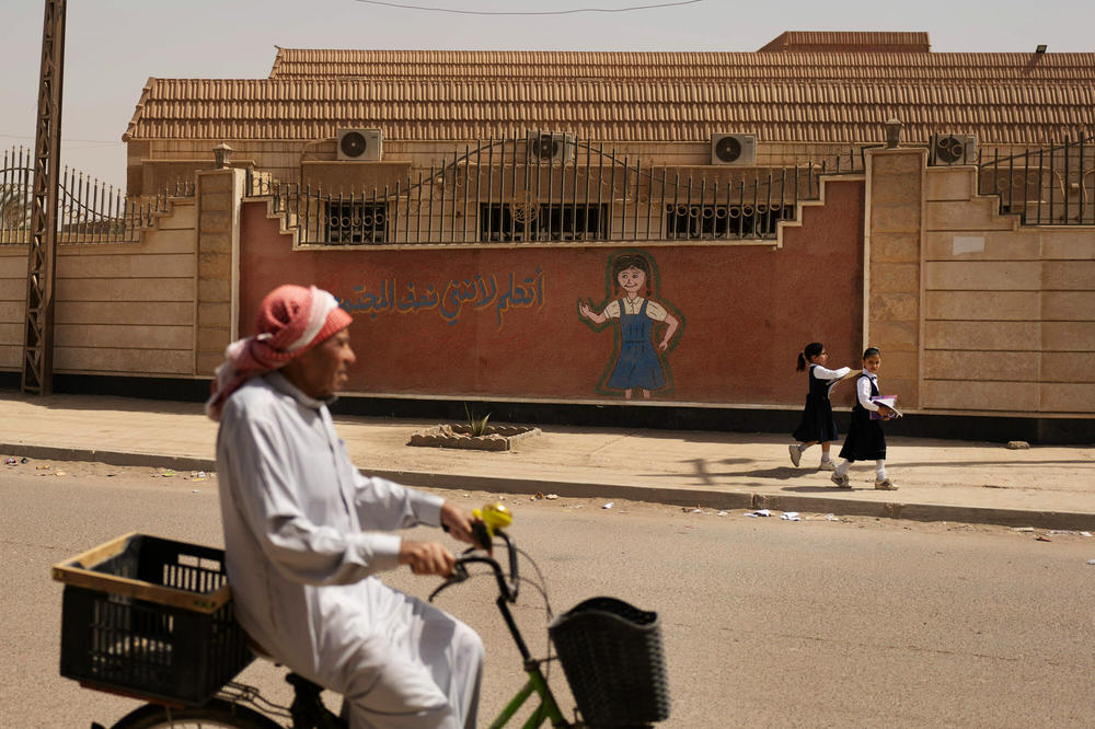 A man cycles past the school in Fallujah where a mortar was accidentally dropped in 2004,  killing two Marines and Shihab.