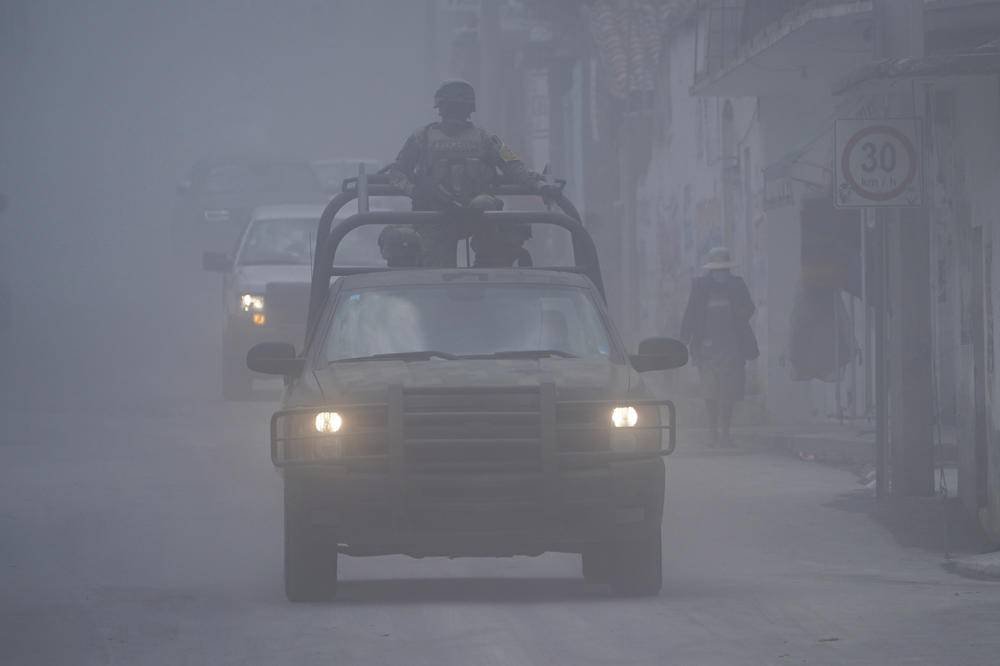 Mexican soldiers drive in Santiago Xalitzintla on Tuesday as ash from the Popocatépetl volcano blankets the streets.