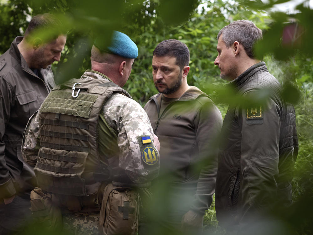 Ukrainian President Volodymyr Zelenskyy listens to military commanders as he visits the eastern Donetsk region, an area of heavy fighting, on Tuesday. Zelenskyy and other Ukrainian officials say a major military offensive is likely to start soon.