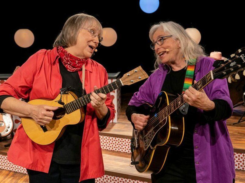 Grammy Award-winning musicians Marcy Marxer and Cathy Fink sing about the unexpected humor they encountered during Marxer's seven-year fight with breast cancer in the concert film, <em>All Wigged Out</em>.